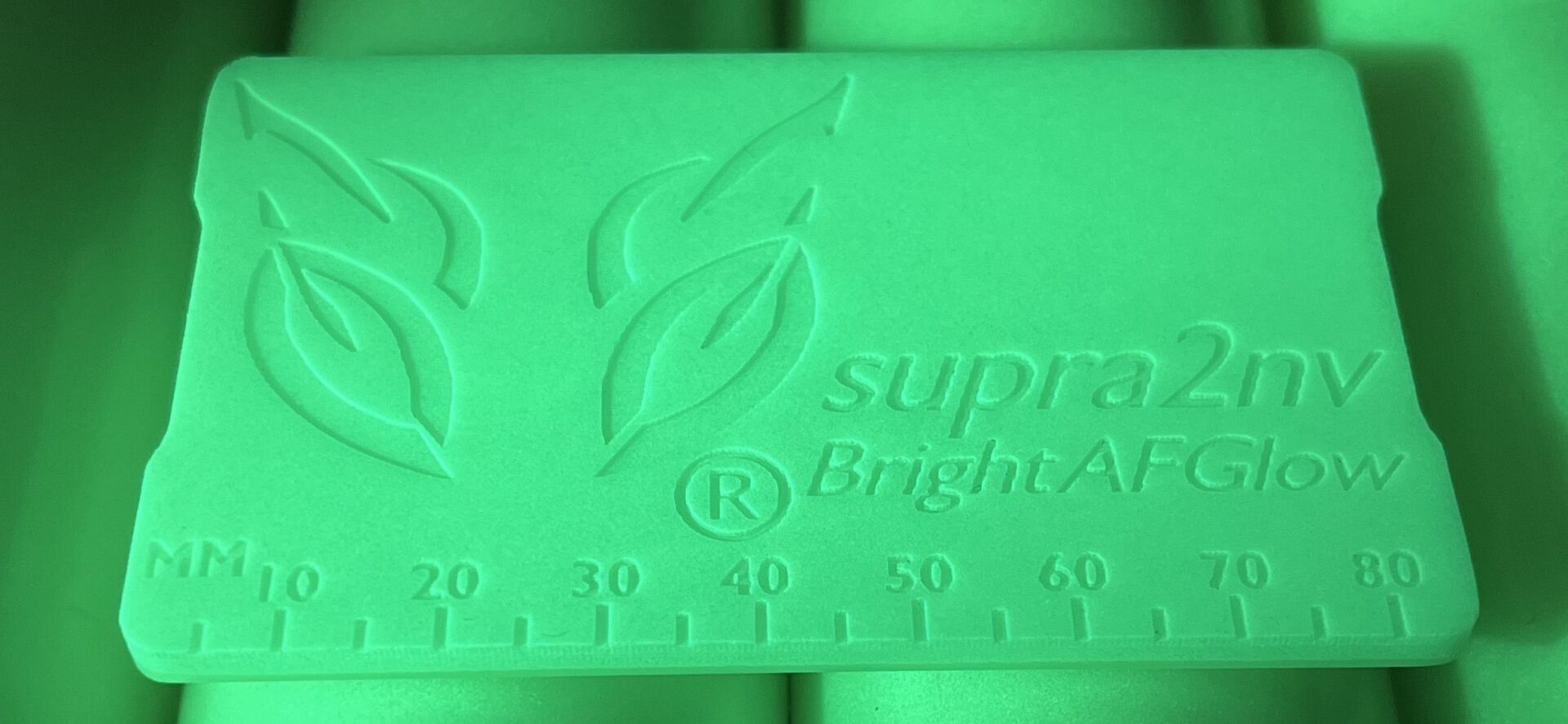 A green rubber stamp with the word " suprax bright algae ".