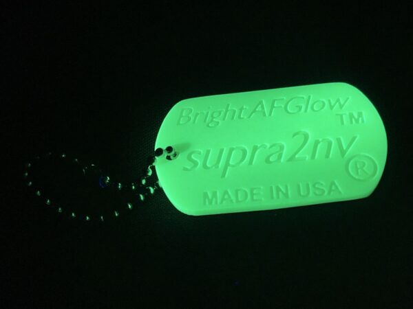 A green tag with the words " supra 2 ny made by glow in the dark."