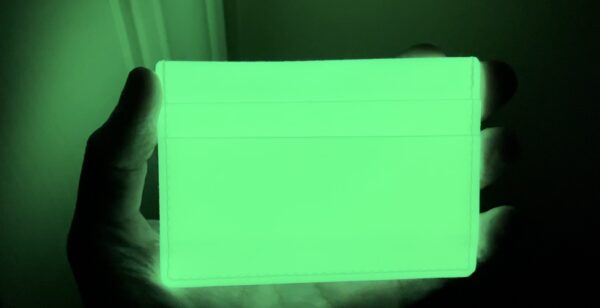 A person is holding a green tablet in their hand.