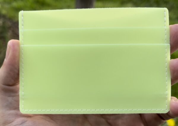 A person holding onto a green wallet