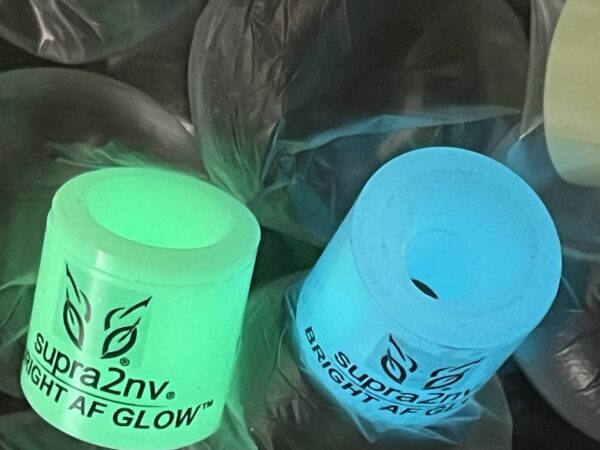 Two glow in the dark candles sitting on top of a plant.