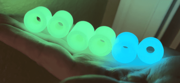 A person is holding some glowing beads in their hand